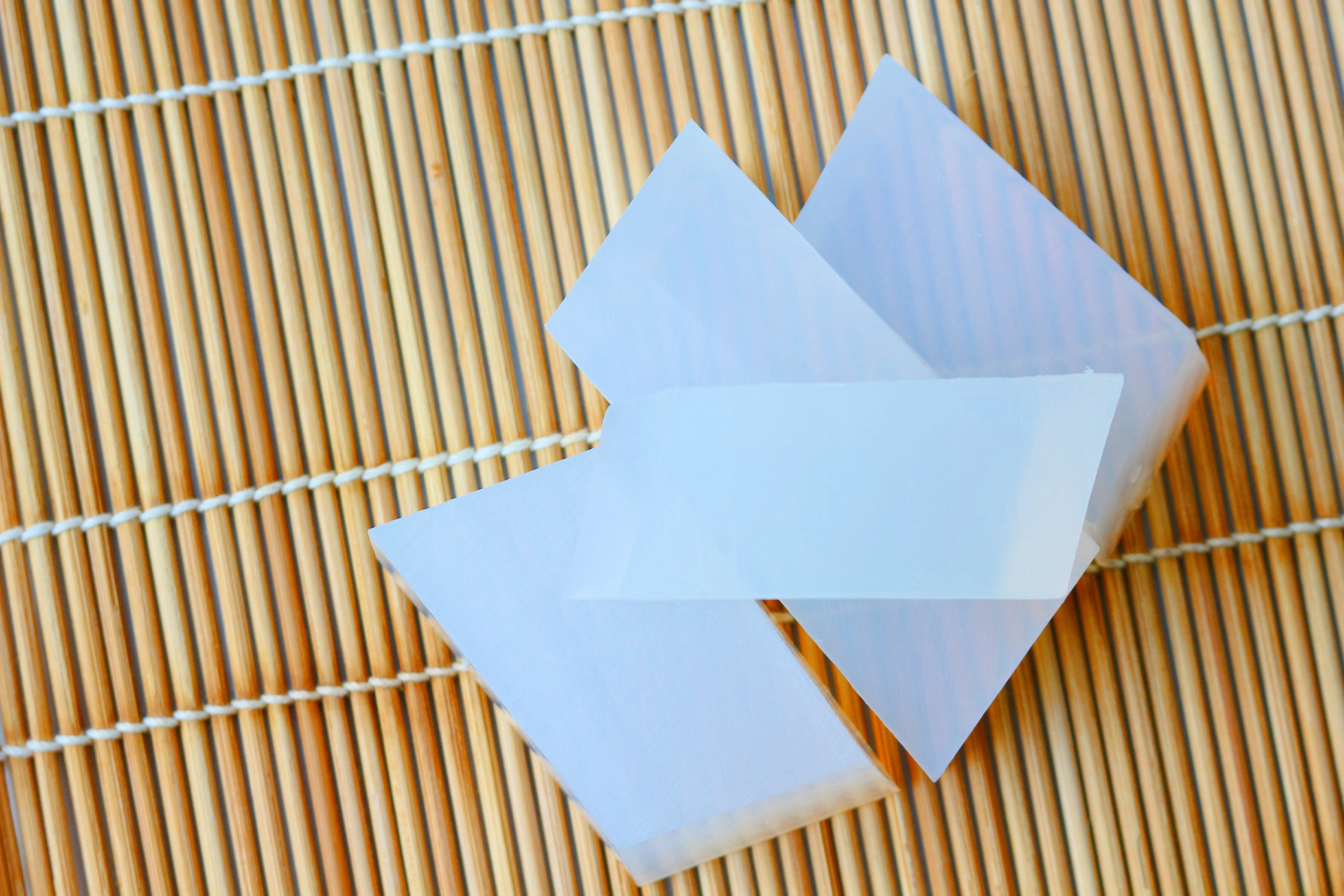 Natural glycerin soap base on bamboo sticks background.